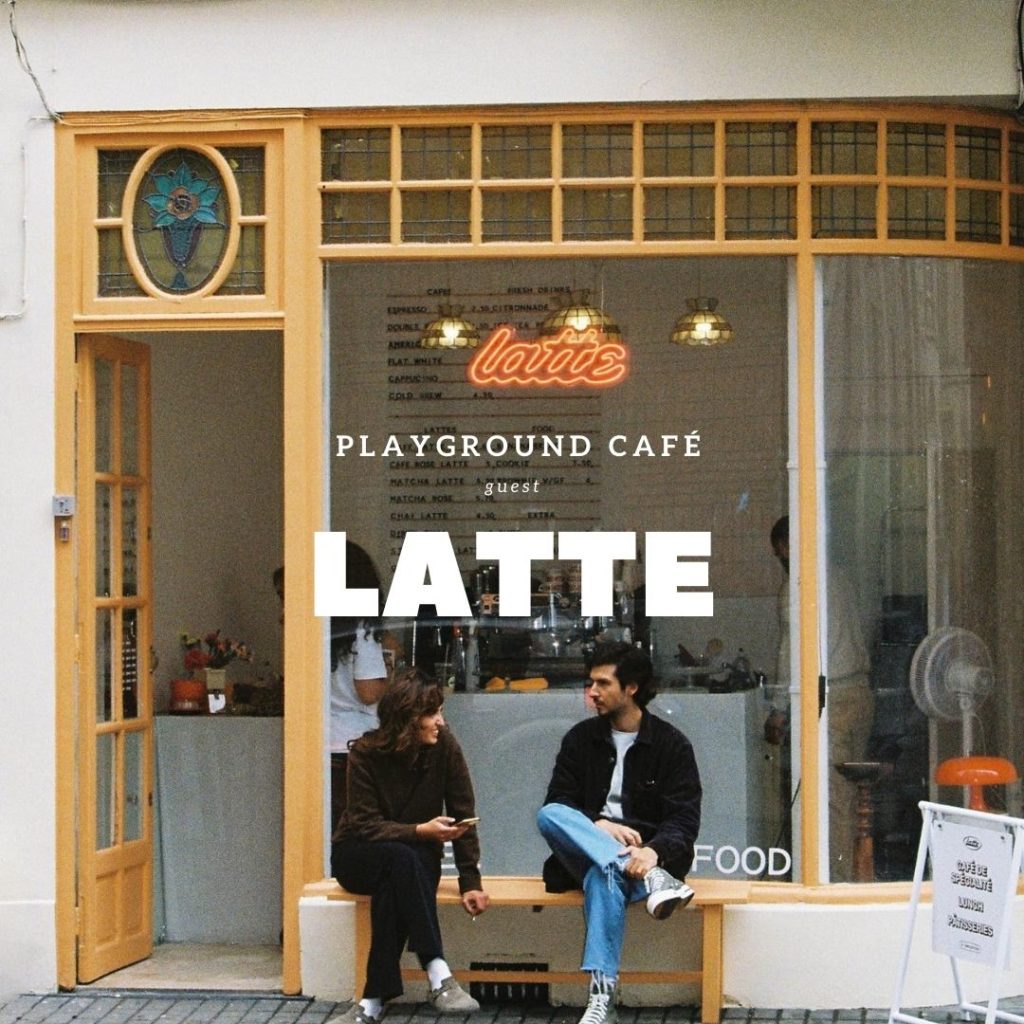photo de un homme et une femme assis sur un banc face à une vitrine avec l'inscription Latte