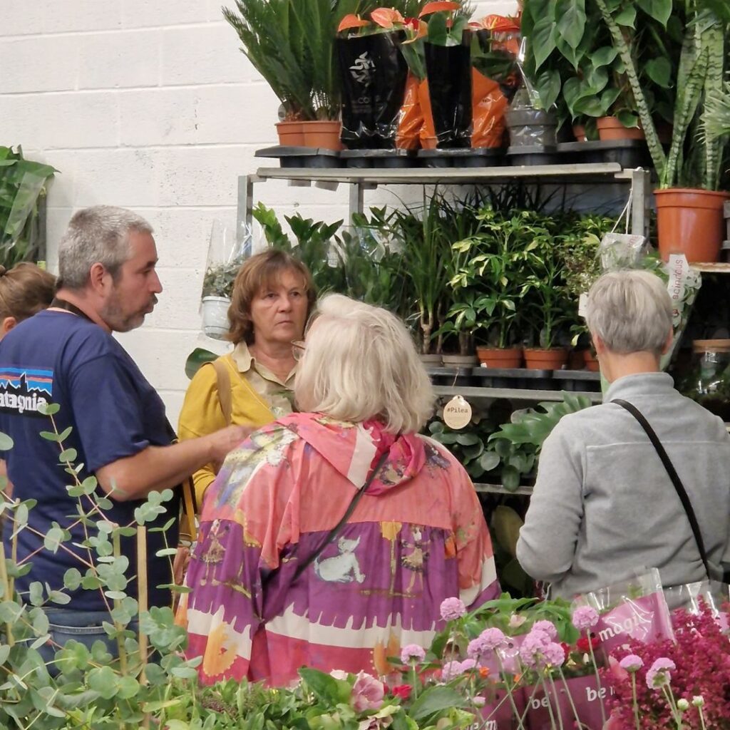 image avec des plantes et trois femmes et un homme qui discutent ensemble